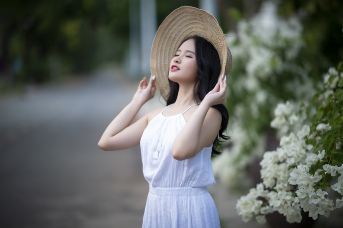 Asian woman in white dress and straw hat