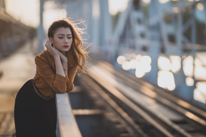 Asian woman on a bridge at sunset
