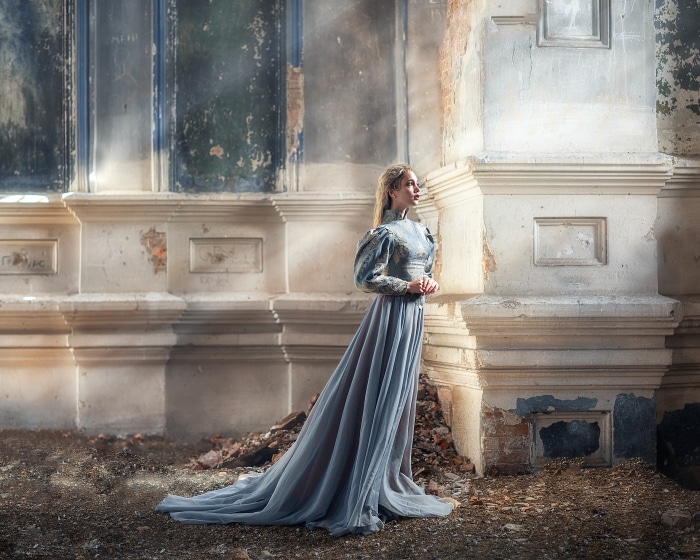 Woman in blue dress in ruined building