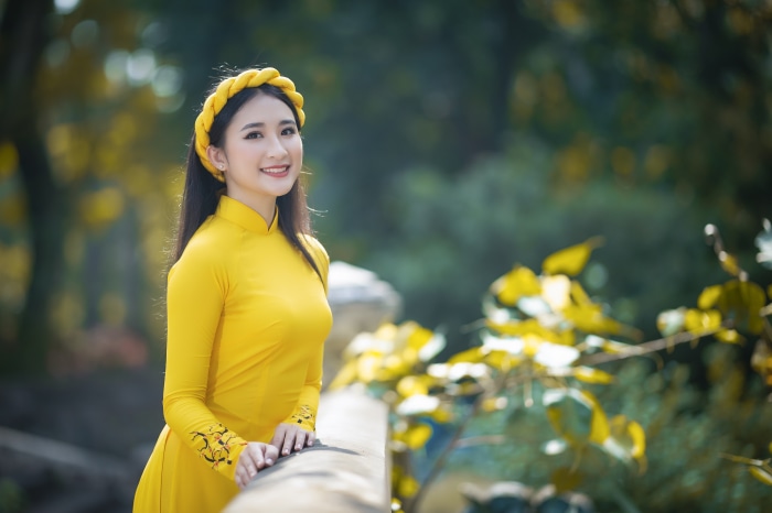 Asian woman in yellow dress with headband