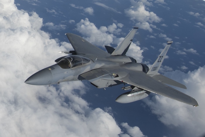 F-15 Eagle fighter jet flying above clouds