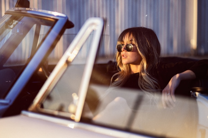 Woman wearing sunglasses in a convertible