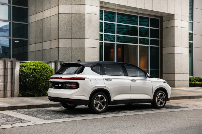 Baojun RM-5 parked near a modern building