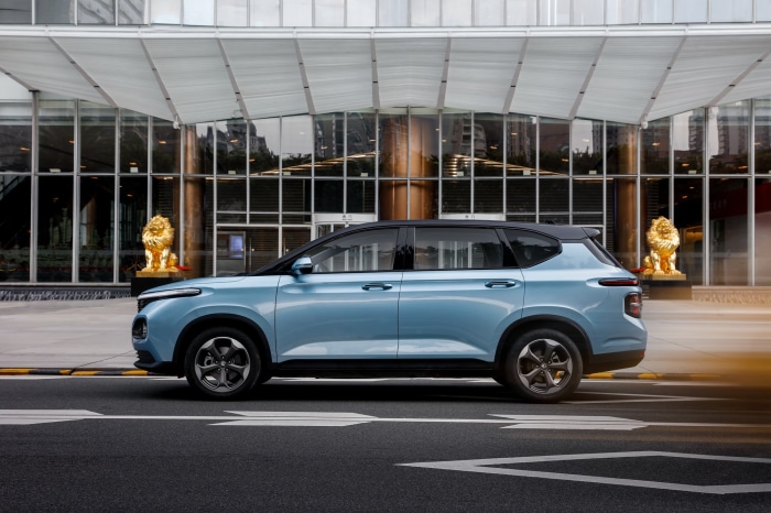 Baojun RM-5 car parked in front of a modern building