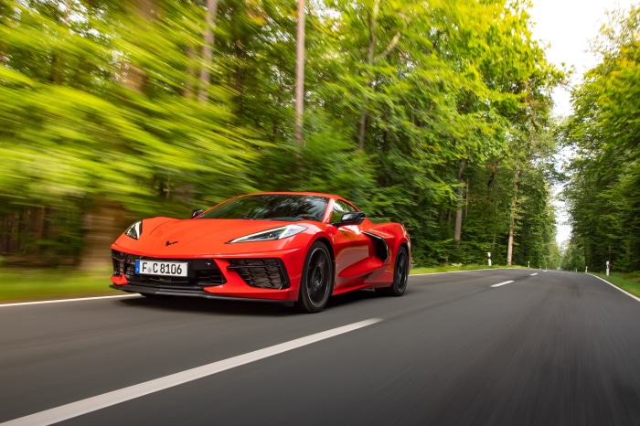 Red Chevrolet Corvette Stingray driving on a road
