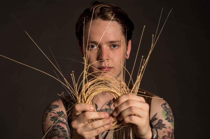 Billy Strings holding guitar strings