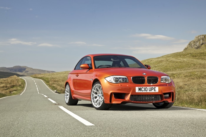Orange BMW 1 Series M Coupe on a Winding Road