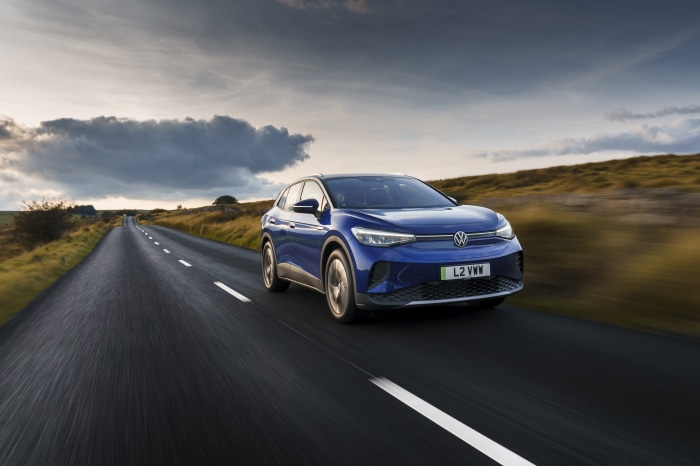 Blue Volkswagen ID.4 electric car driving on a rural road