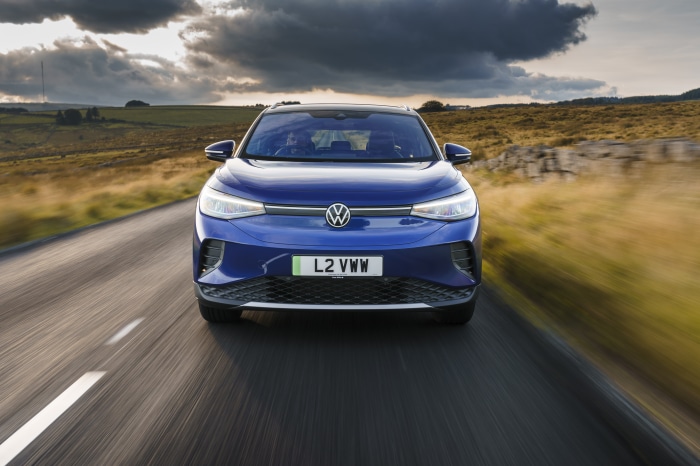 Blue Volkswagen ID.4 electric car driving on a road