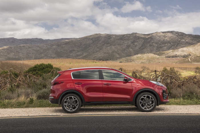 Red Kia Sportage SUV parked on a roadside