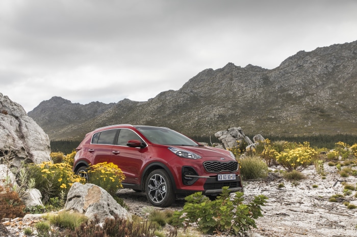 Red Kia Sportage SUV in a rocky, mountainous landscape