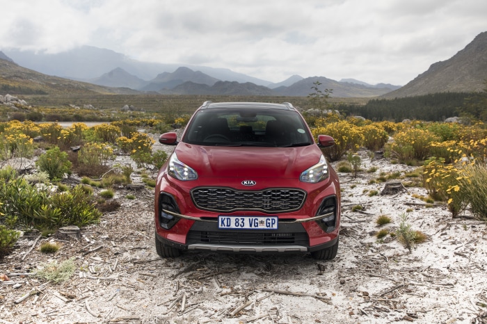 Red Kia Sportage SUV in a natural landscape