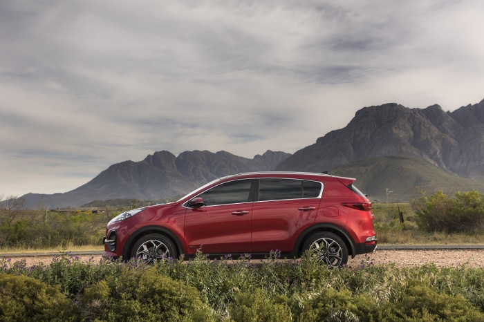 Red Kia Sportage SUV parked near mountains