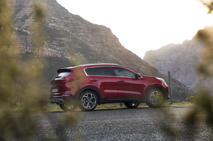 Red Kia Sportage SUV on a mountain road