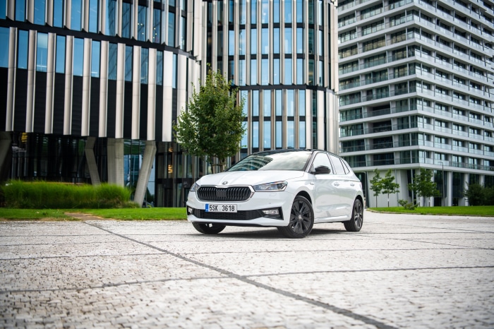 White Skoda Fabia parked in front of modern buildings