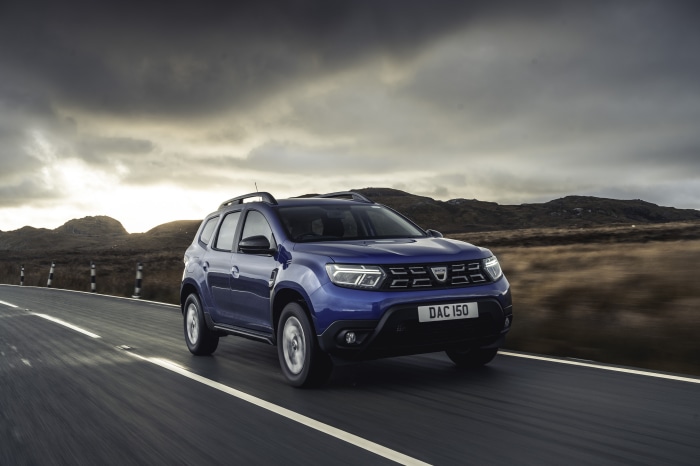 Blue Dacia Duster driving on a road