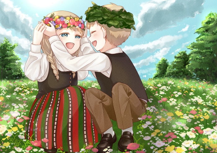 Children in traditional clothing with flower and leaf crowns in a meadow