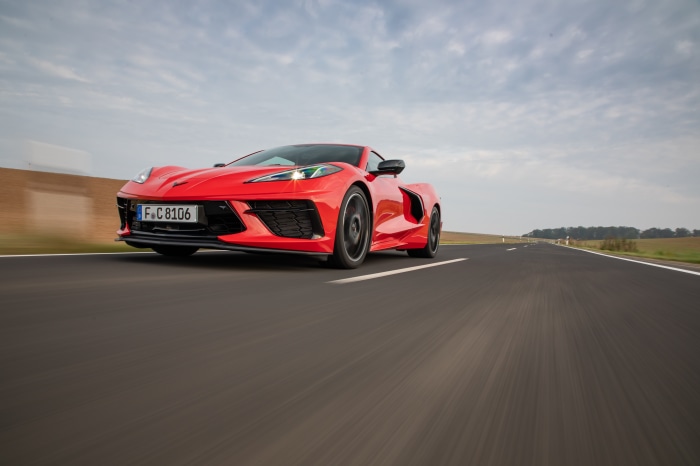 Red Chevrolet Corvette C8 driving on a road