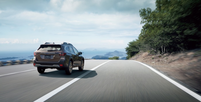 Subaru Outback driving on a coastal road