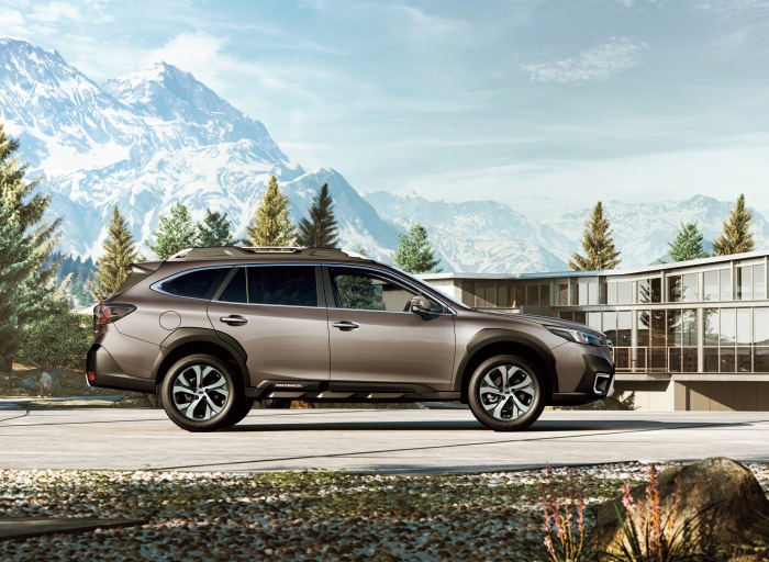 Subaru Outback parked near a modern building and mountains