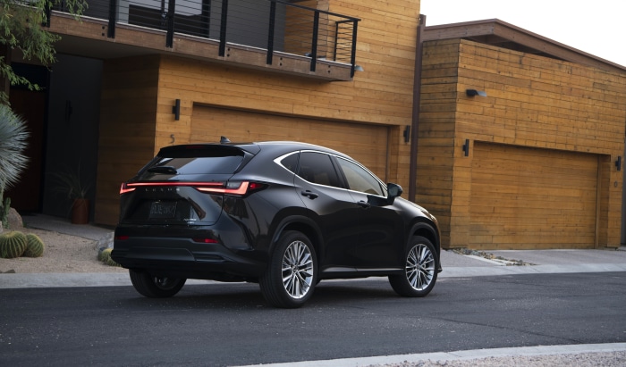 Black Lexus NX 350 AWD parked in front of a modern house