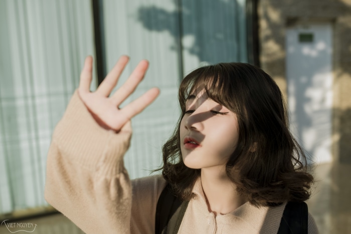 Asian girl shielding her eyes from the sun