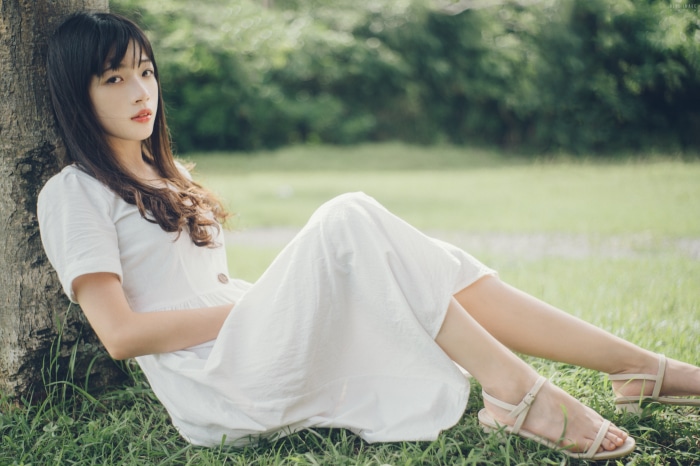 Asian Girl sitting by a tree
