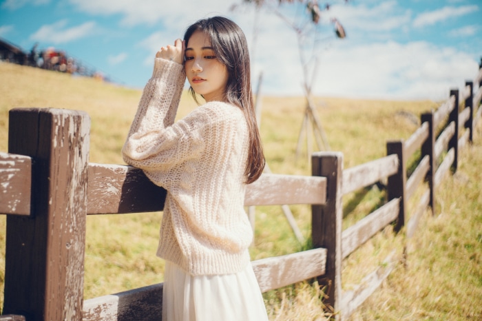 Asian Girl leaning on a wooden fence