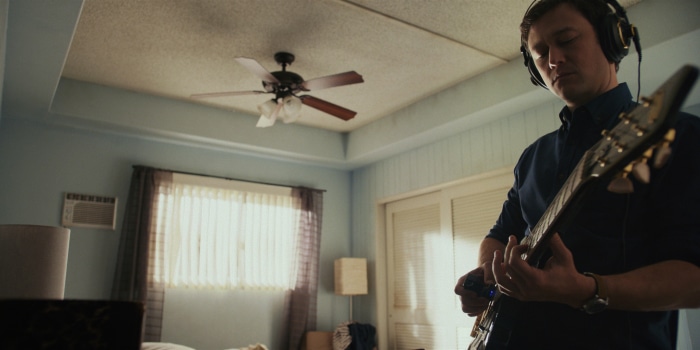 Joseph Gordon-Levitt playing guitar with headphones