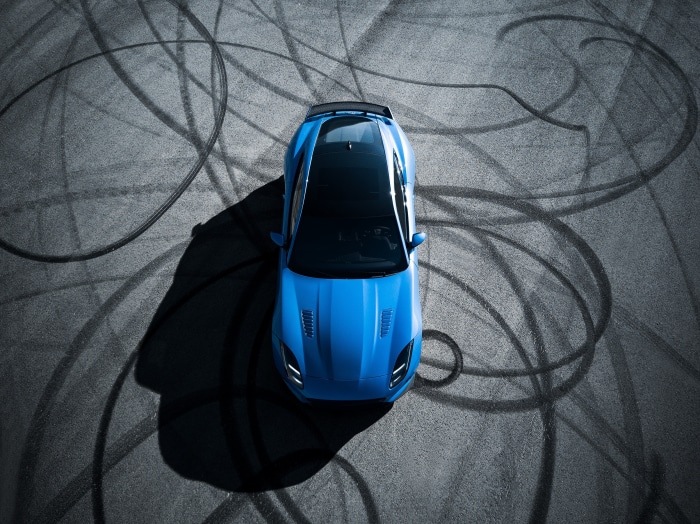 Blue Jaguar F-Type on asphalt with tire marks