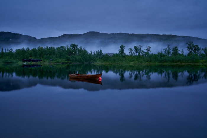Wooden boat with red buoy on a lake in Norway