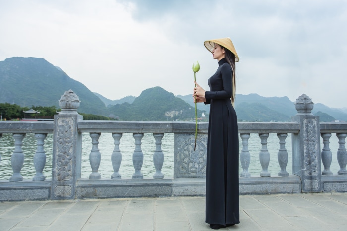 Woman in black dress holding lotus flower