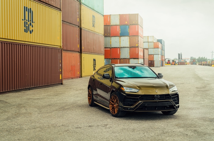 Lamborghini Urus SUV parked at shipping containers