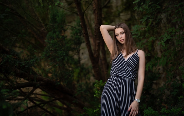 Young woman in a striped jumpsuit posing outdoors