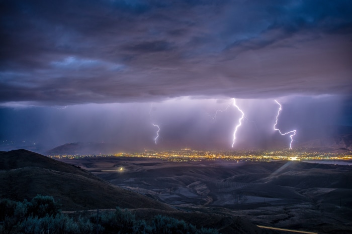 Lightning strikes over a city at night