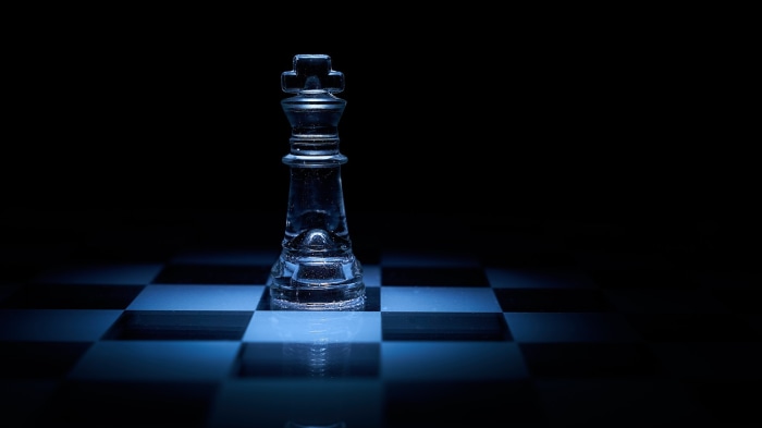 Glass chess king on a chessboard