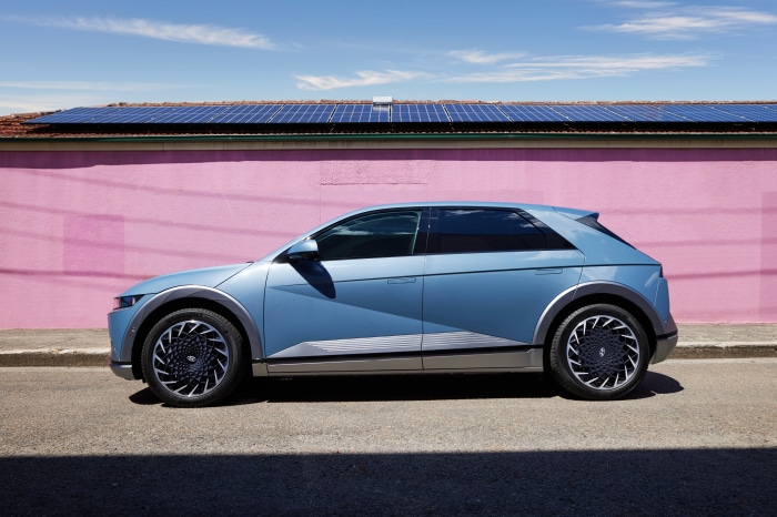 Blue Hyundai Ioniq 5 SUV parked in front of pink wall