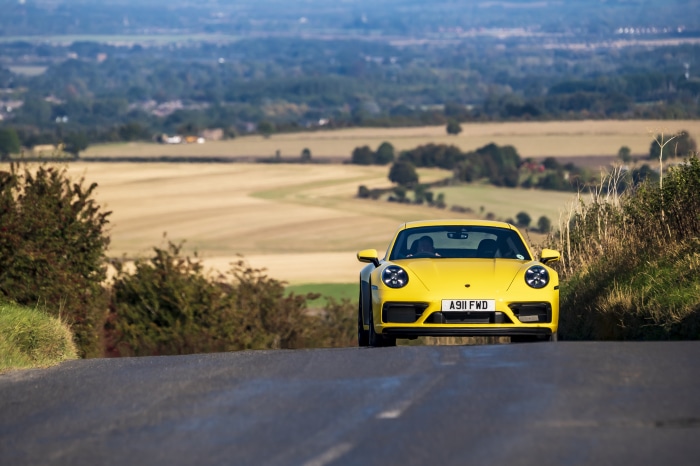 Yellow Porsche 911 Carrera GTS on a country road