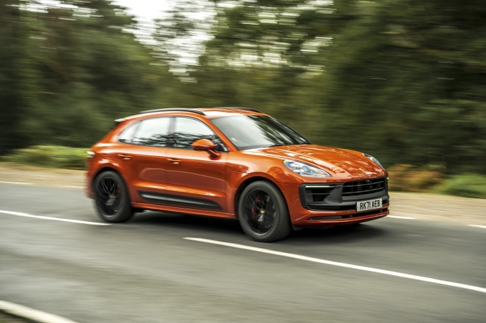 Orange Porsche Macan GTS SUV driving on a road