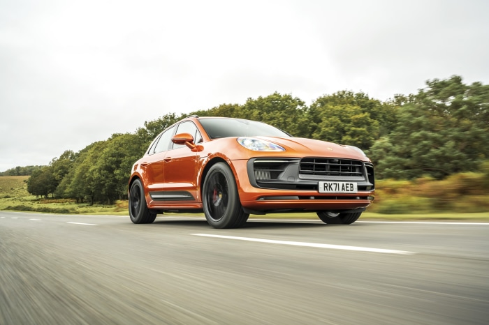 Orange Porsche Macan GTS driving on a road