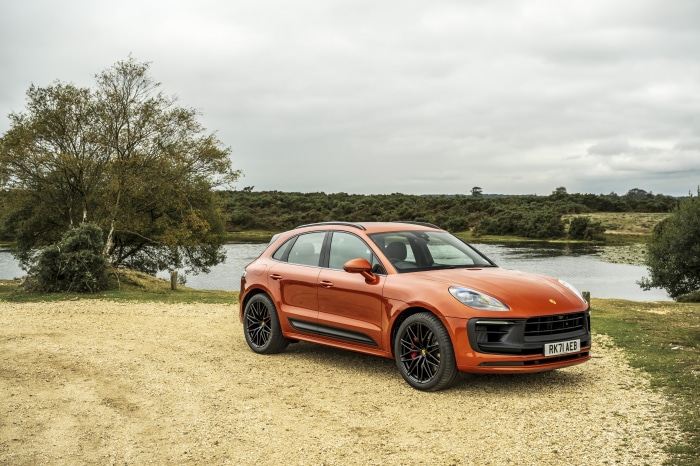 Orange Porsche Macan GTS SUV parked by a lake