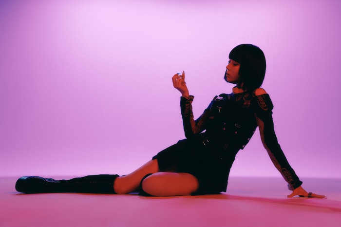 Winter from Aespa posing on a pink background
