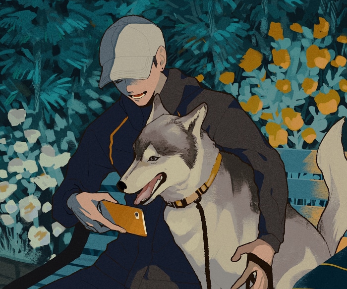 Boy with husky looking at phone on bench
