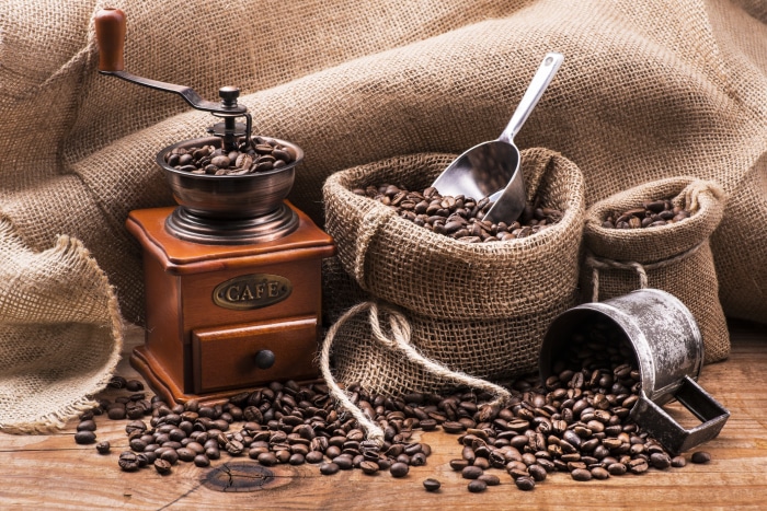 Coffee grinder and beans in burlap sacks