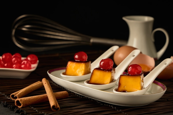 Dessert still life with flan, cherries, and cinnamon