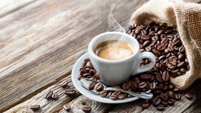 Espresso cup with coffee beans and burlap sack