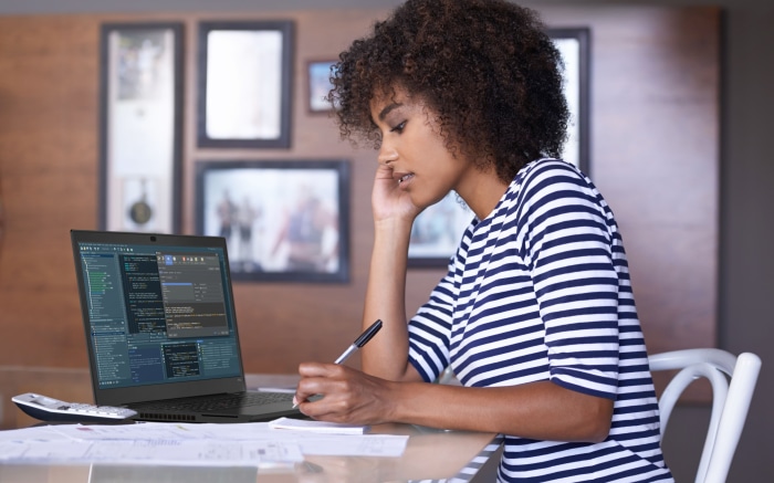 Woman working on a laptop with code