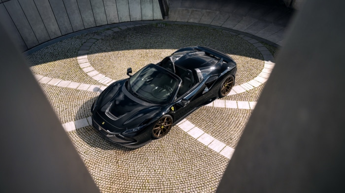 Black Ferrari F8 Spider parked on cobblestone