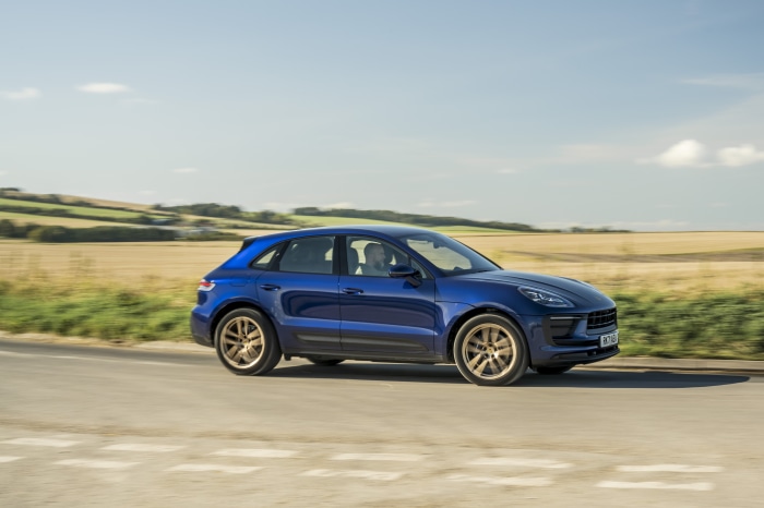 Blue Porsche Macan driving on a road