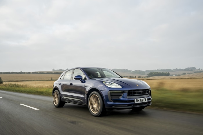 Blue Porsche Macan SUV driving on a road